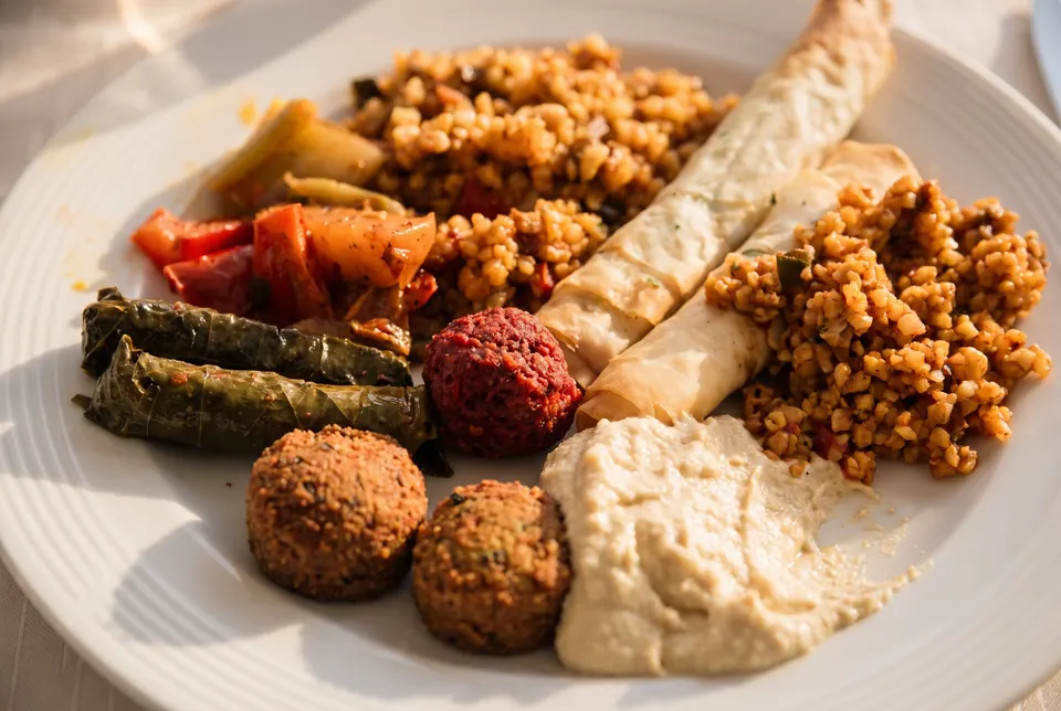 Plate from the buffet with falafel, beetroot falafel, hummus, sarma, cheese cigars, bulgur and vegetables (illustrative image)