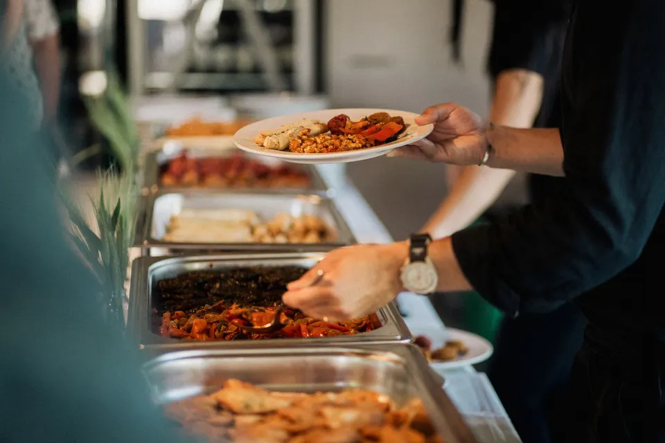 Catering-Service: Gäste bedienen sich am Buffet mit Chafing Dishes